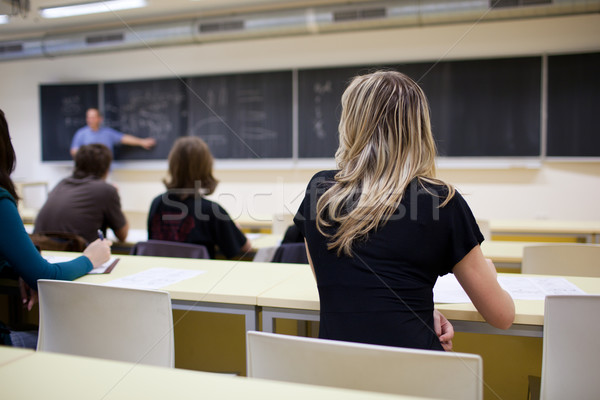 young pretty female college student sitting in a classroom full  Stock photo © lightpoet