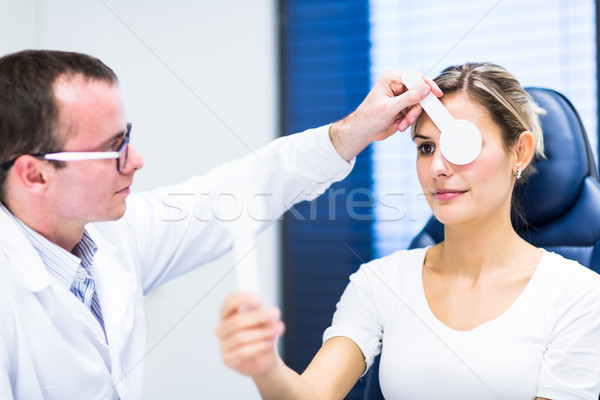 Hhandsome young man having his eyes examined by an eye doctor Stock photo © lightpoet