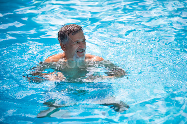 Senior man in his home swimming pool Stock photo © lightpoet