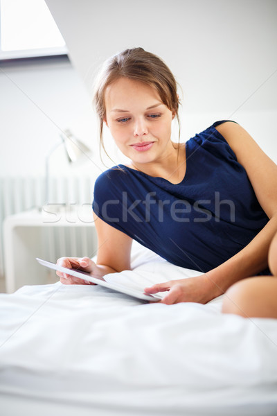 Elegant, smart, young woman using her tablet computer in bed  Stock photo © lightpoet