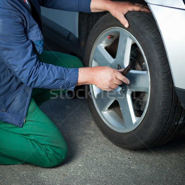 Stock photo: mechanic changing a wheel of a modern car 