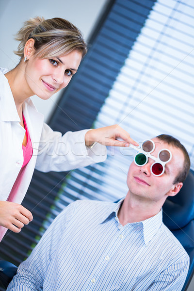 Hhandsome young man having his eyes examined by an eye doctor Stock photo © lightpoet
