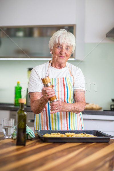 Senior woman cooking in the kitchen - eating and cooking healthy Stock photo © lightpoet