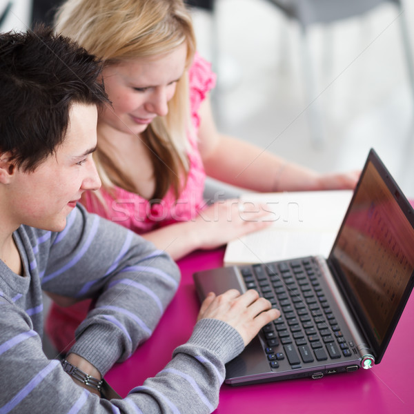 Two college students having fun studying together, using a lapto Stock photo © lightpoet