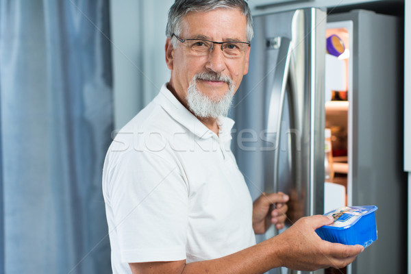 Senior man in his kitchen by the fridge  Stock photo © lightpoet