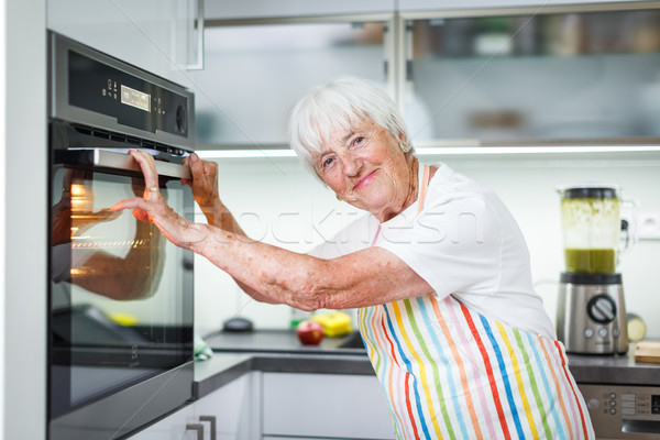 Senior woman cooking in the kitchen - eating and cooking healthy Stock photo © lightpoet