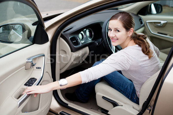 Stock photo: Pretty young woman driving her brand new car 