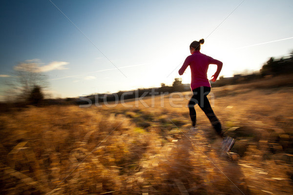 Stock photo: Young woman running outdoors on a lovely sunny winter/fall day 