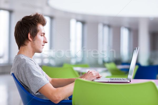 Stock photo: college student using his laptop computer
