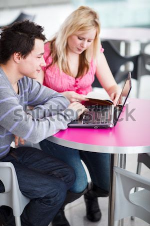 Two college students having fun studying together, using a lapto Stock photo © lightpoet