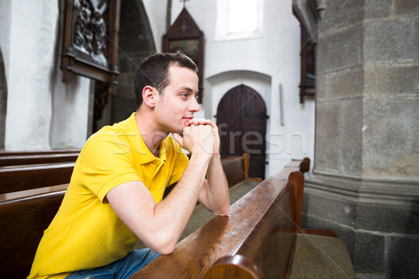 Handsome young man praying in a church Stock photo © lightpoet