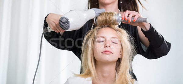 Pretty, young woman having her hair done by a professional hairs Stock photo © lightpoet