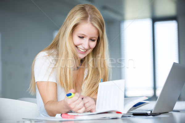 In the library - female student with books, papers and laptop Stock photo © lightpoet