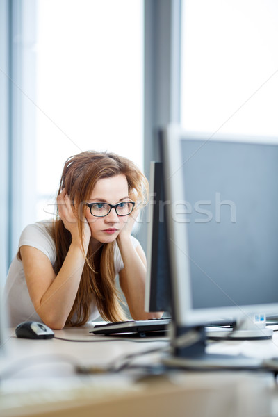 Pretty, female student looking at a desktop computer screen Stock photo © lightpoet