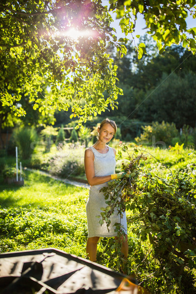 Pretty, young woman gardening in her garden, cutting branches Stock photo © lightpoet