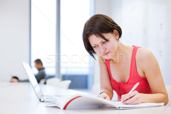 Pretty young college student studying in the library/a study roo Stock photo © lightpoet