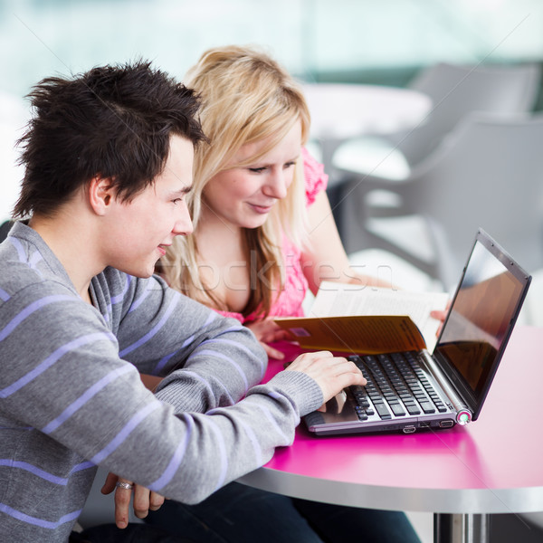 Two college students having fun studying together, using a lapto Stock photo © lightpoet