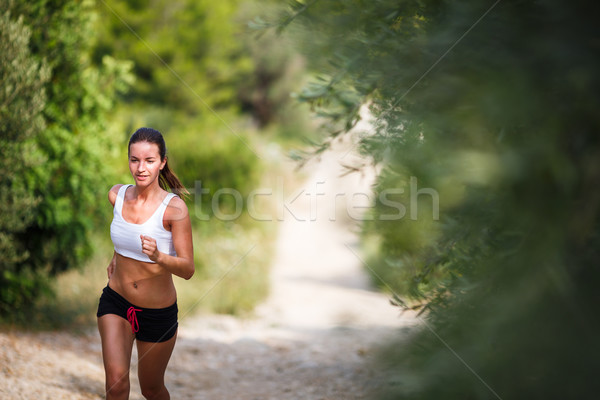 Beautiful young female runner on a forest path, on a lovely day Stock photo © lightpoet