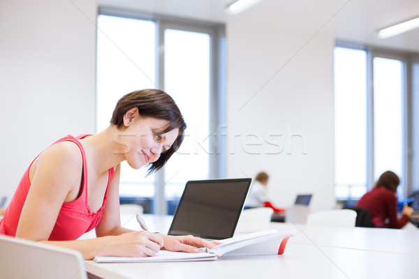 Pretty young college student studying in the library Stock photo © lightpoet