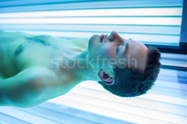Handsome young man relaxing during a tanning session Stock photo © lightpoet