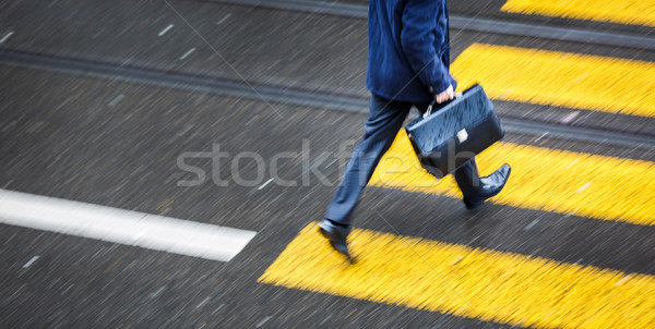 Man rushing over a road crossing in a city on a rainy day Stock photo © lightpoet