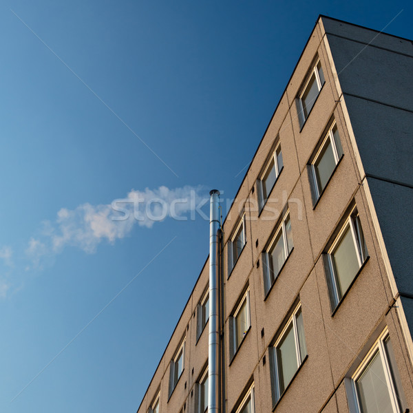 smoke/flue gases going out of a chimney by an apartment building Stock photo © lightpoet