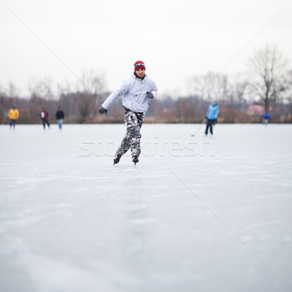 Young woman ice skating outdoors on a pond Stock photo © lightpoet