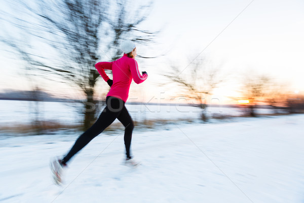 Young woman running outdoors on a cold winter day (motion blurre Stock photo © lightpoet