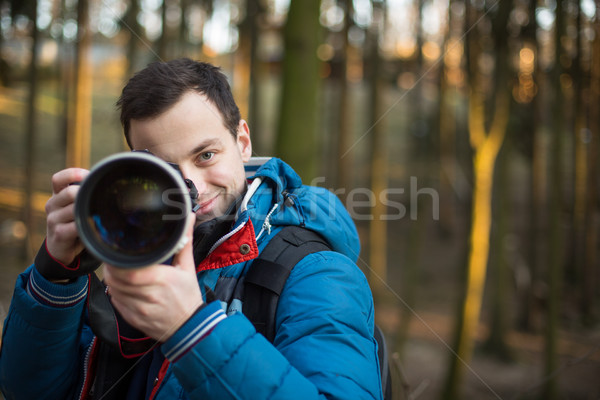 Young, male photographer taking photos with his huge, new, shiny Stock photo © lightpoet