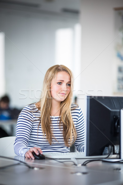 Pretty, female student looking at a desktop computer screen Stock photo © lightpoet