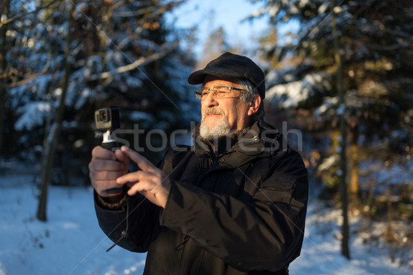 Handsome senior man shotting video with his adventura outdoor camera Stock photo © lightpoet