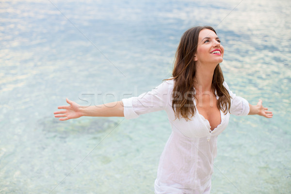 Woman relaxing at the beach with arms open enjoying her freedom, Stock photo © lightpoet