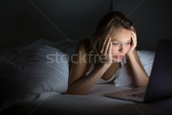 Mooie jonge vrouw kijken iets laptop bed Stockfoto © lightpoet
