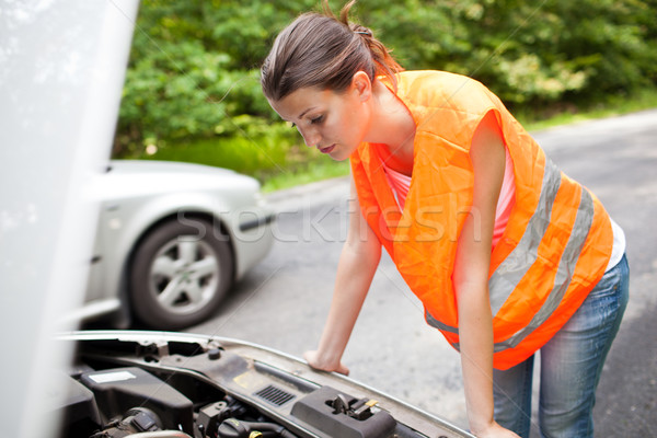 Young female driver bending over  the engine of her broken down car Stock photo © lightpoet