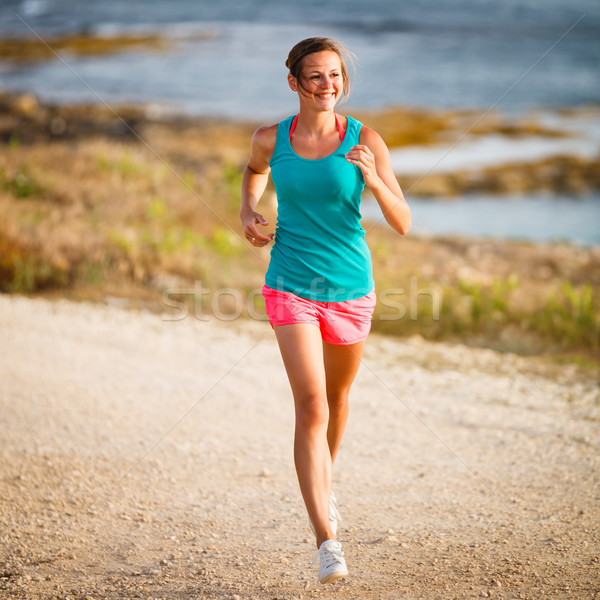 Young woman on her evening jog along the seacoast ( Stock photo © lightpoet