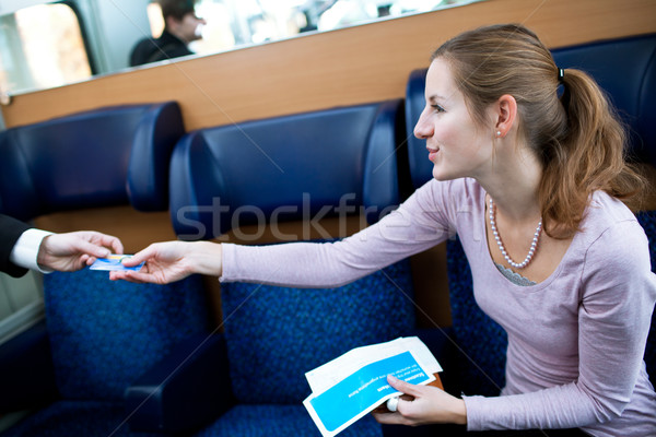 Young woman  having her ticket checked by the train conductor Stock photo © lightpoet