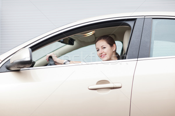 Stock photo: Pretty young woman driving her new car 