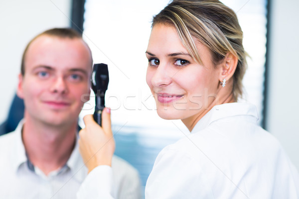 Handsome young man having his eyes examined by an eye doctor Stock photo © lightpoet