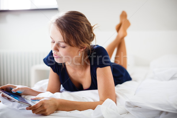 Elegant, smart, young woman using her tablet computer in bed Stock photo © lightpoet