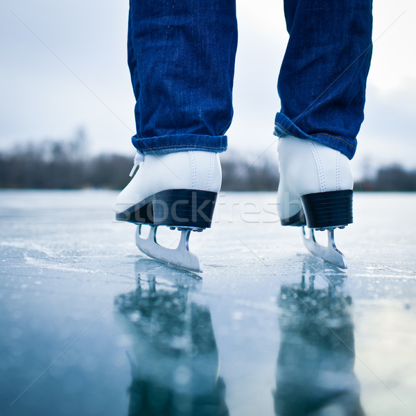 Young woman ice skating outdoors on a pond on a freezing winter  Stock photo © lightpoet