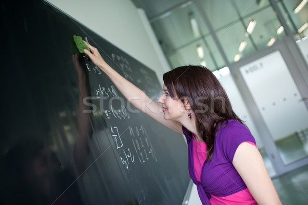 Stock photo: pretty young college student writing on the chalkboard/blackboar