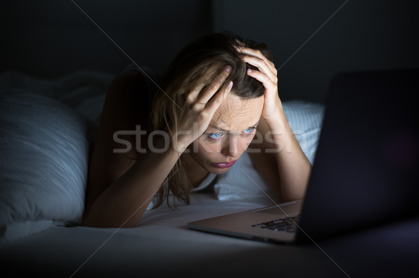 Mooie jonge vrouw kijken iets laptop bed Stockfoto © lightpoet