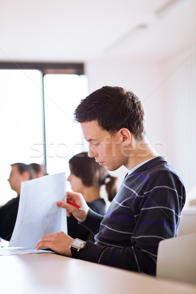 Stock photo: young, handsome male college student sitting in a classroom