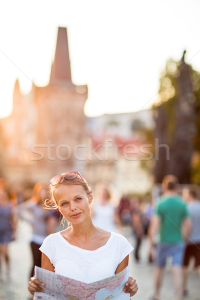 Stock photo: Pretty young female tourist studying a map