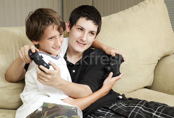 Hermanos jugando videojuegos dos cariñoso junto Foto stock © lisafx