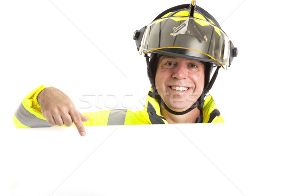 Amistoso bombero mensaje uniforme senalando blanco Foto stock © lisafx