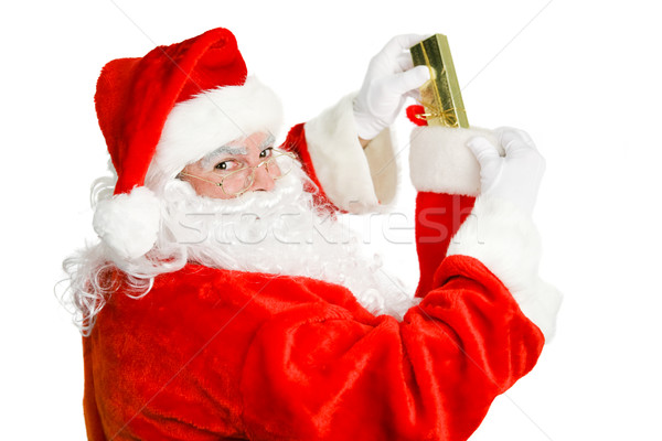 Santa Claus Stuffs a Christmas Stocking Stock photo © lisafx
