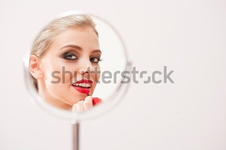  Blond beauty putting on makeup. Stock photo © lithian