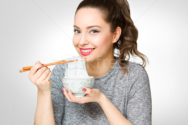 Cute brunette eating asian food. Stock photo © lithian