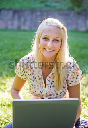 Stock photo: Beautiful young blonde using laptop in nature.